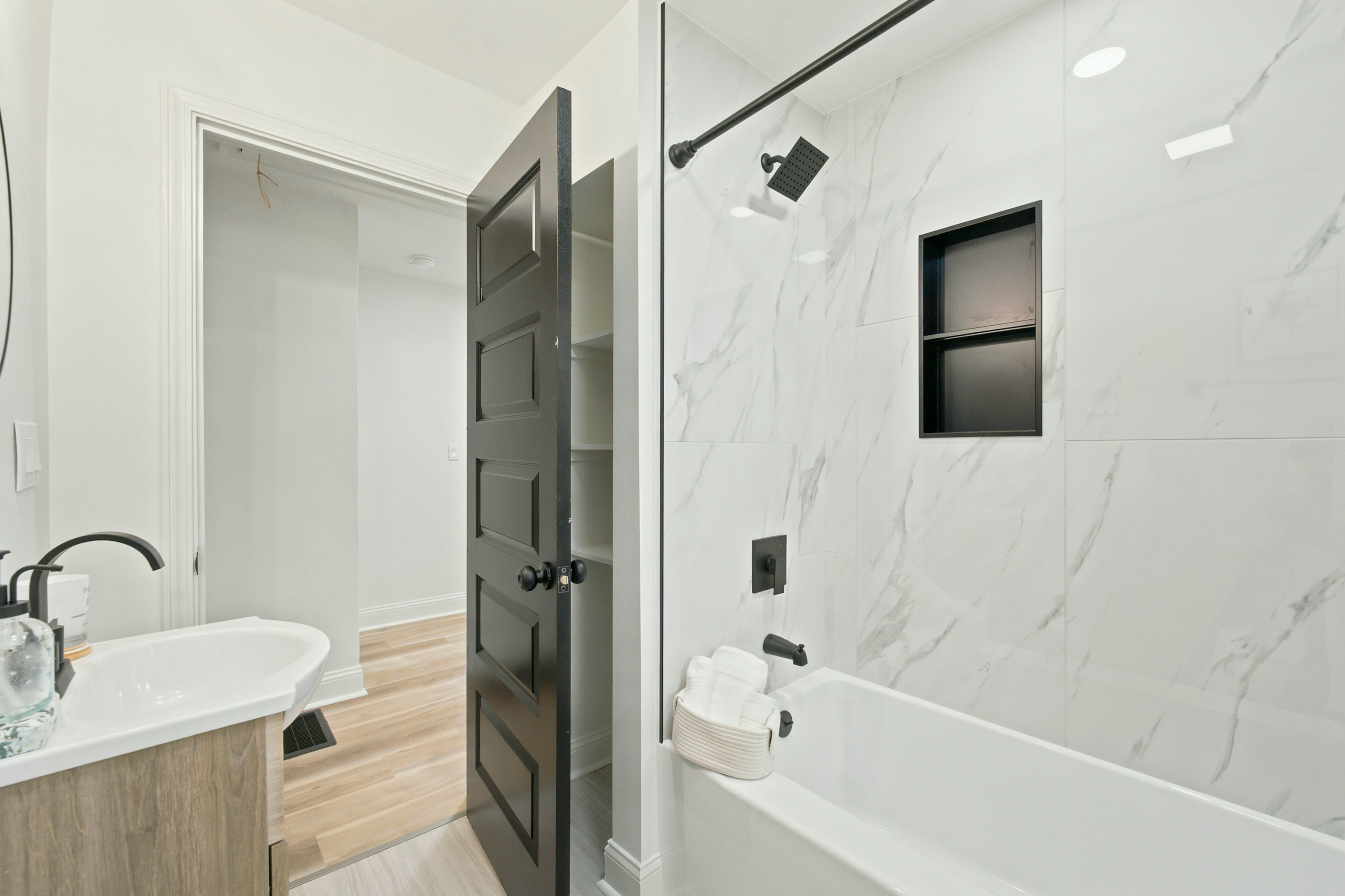 Bathroom with marble tub surround and black fixtures