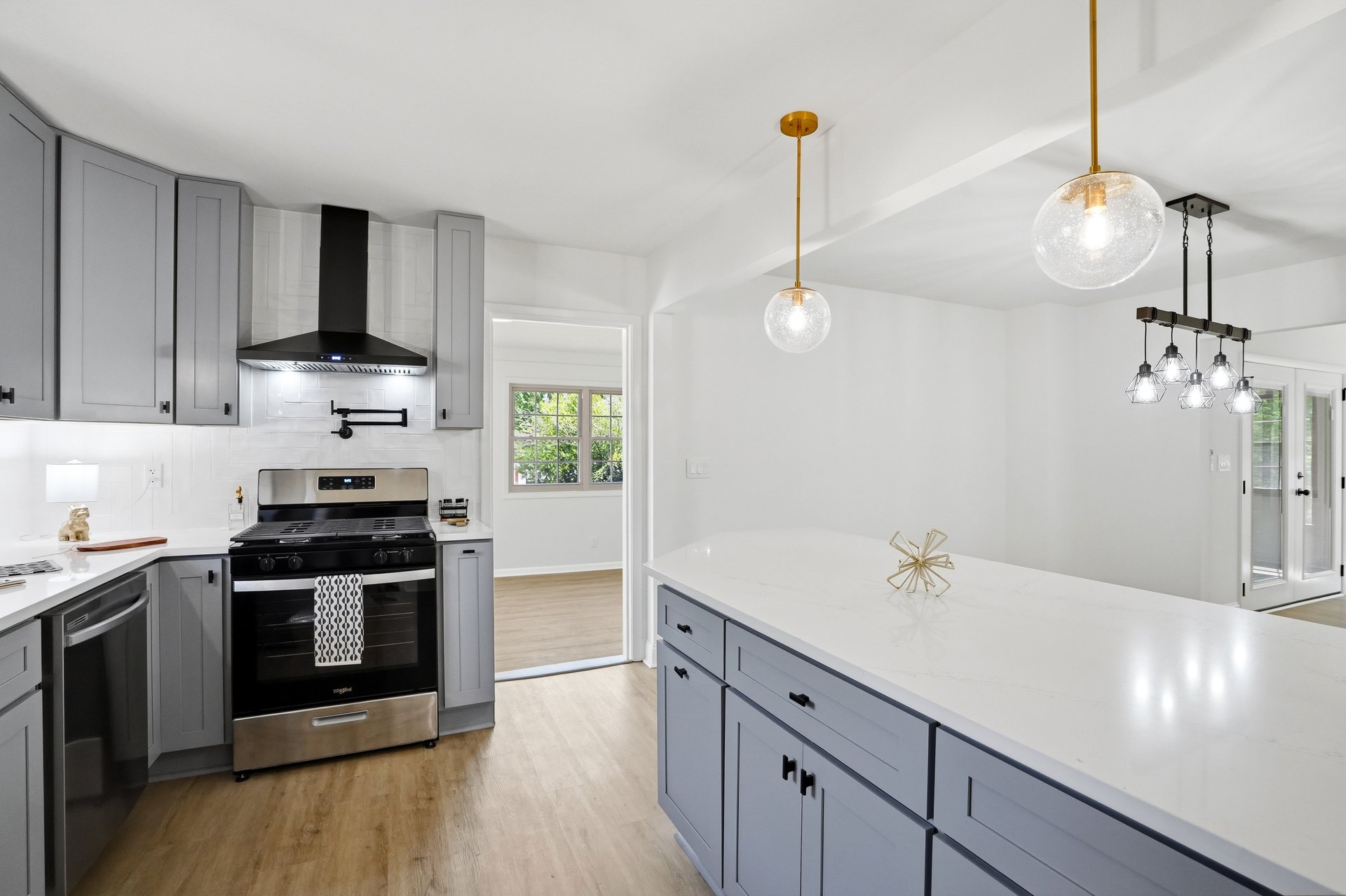 Gray kitchen with white island and gold pendant lights