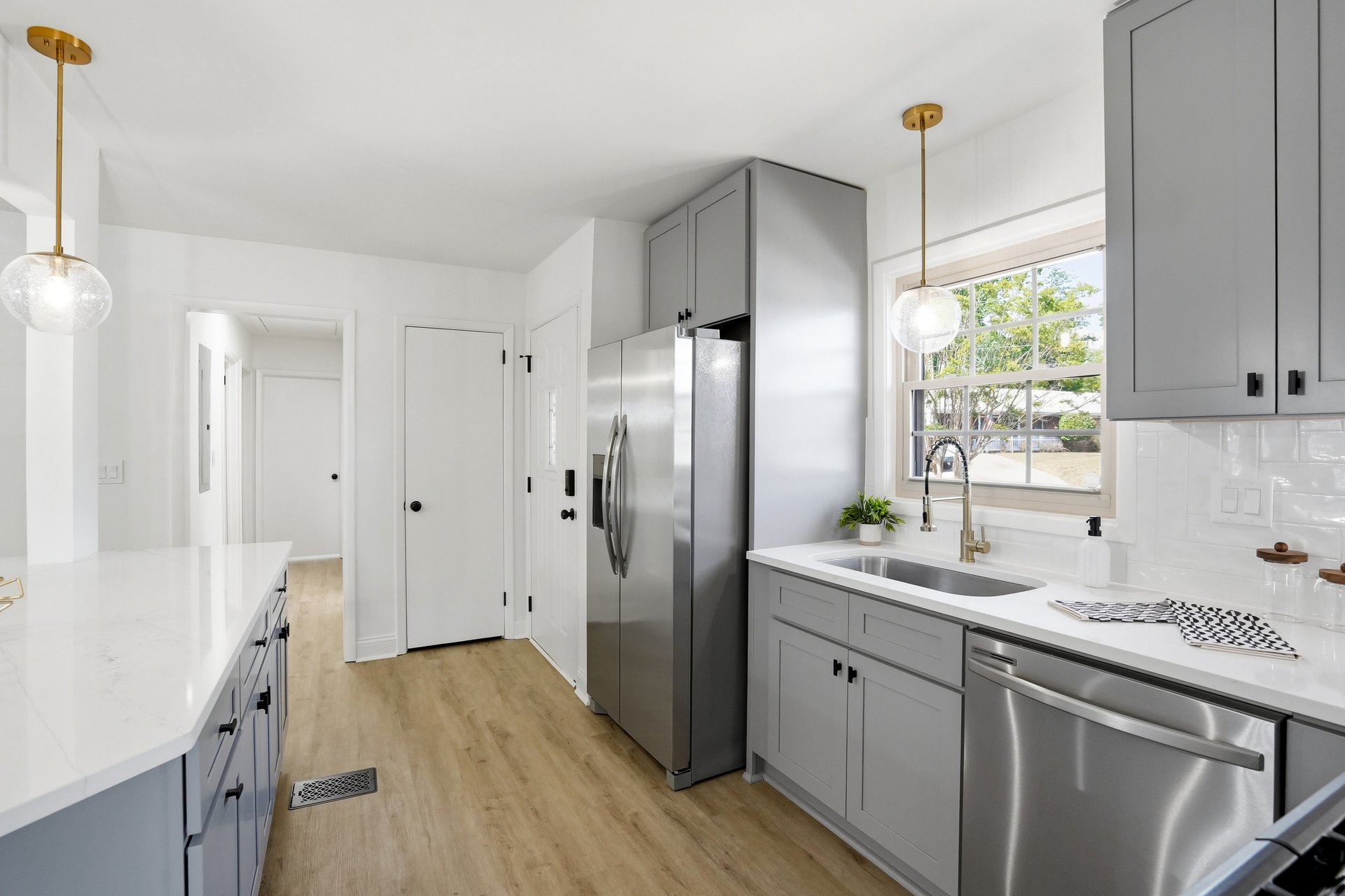 Gray kitchen with stainless fridge and gold faucet