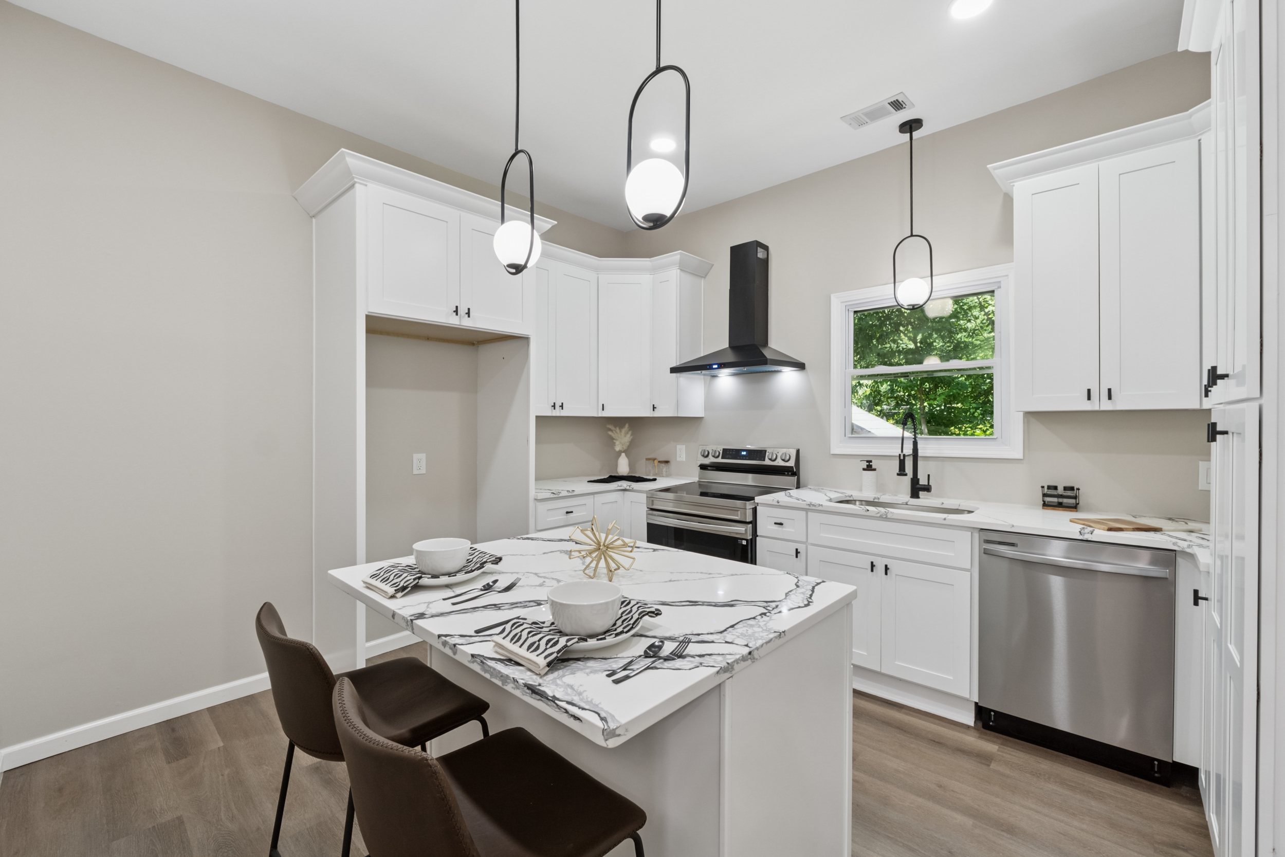 White kitchen with marble island and black pendant lights