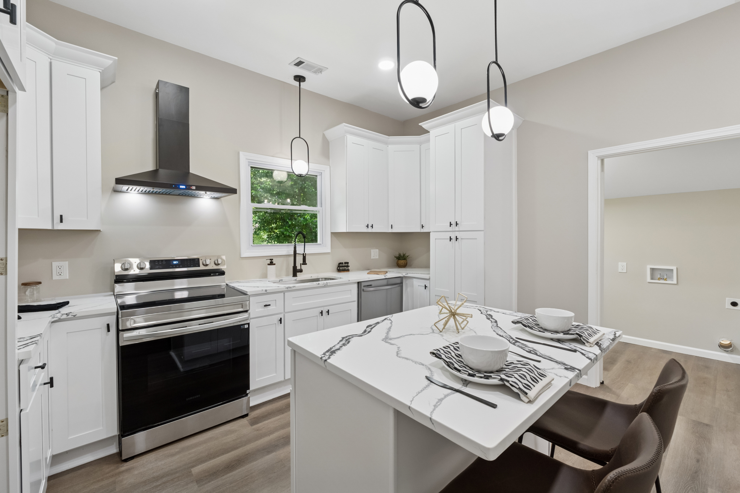 White kitchen with stainless range and black hood