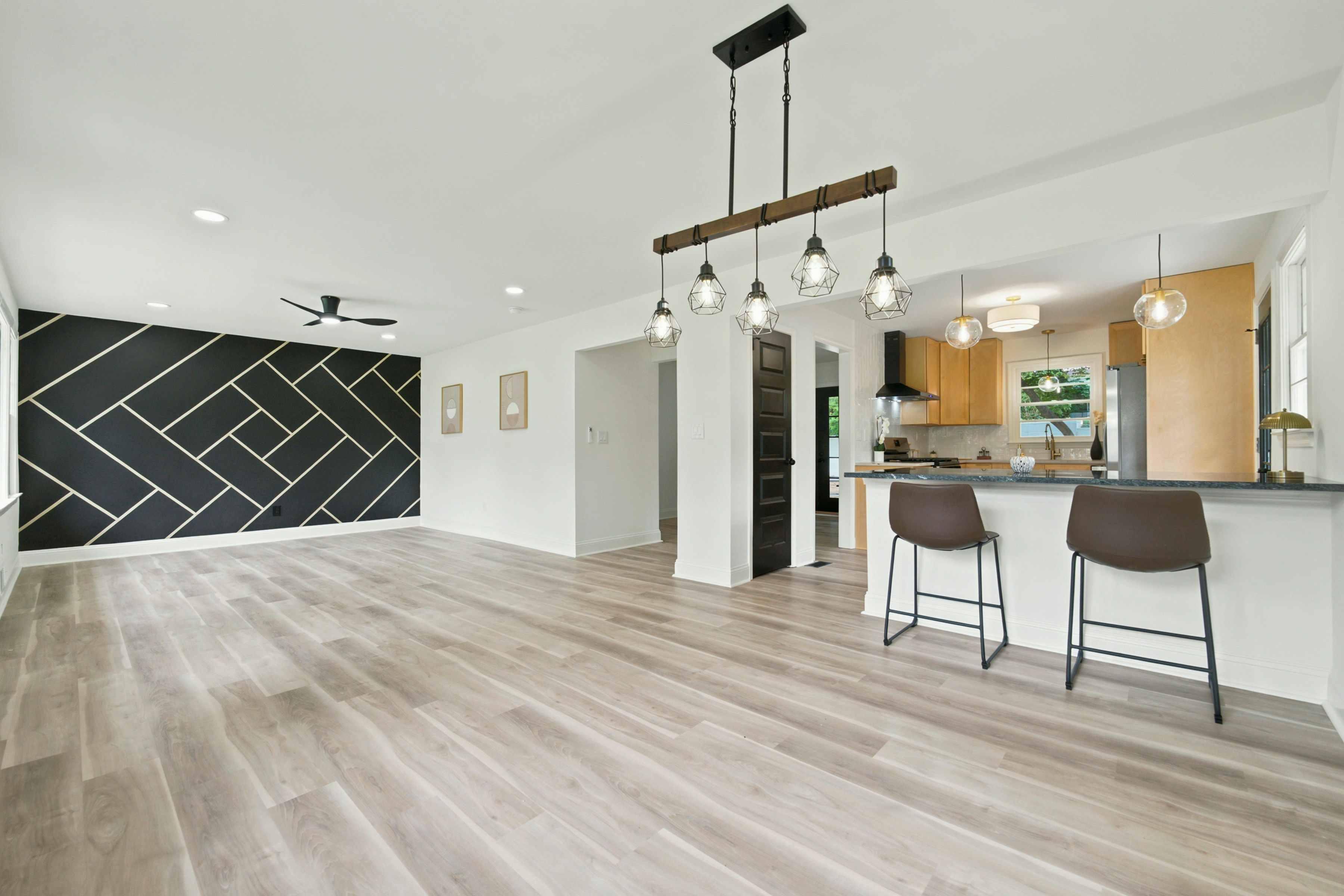 Open living area with bar seating and geometric accent wall